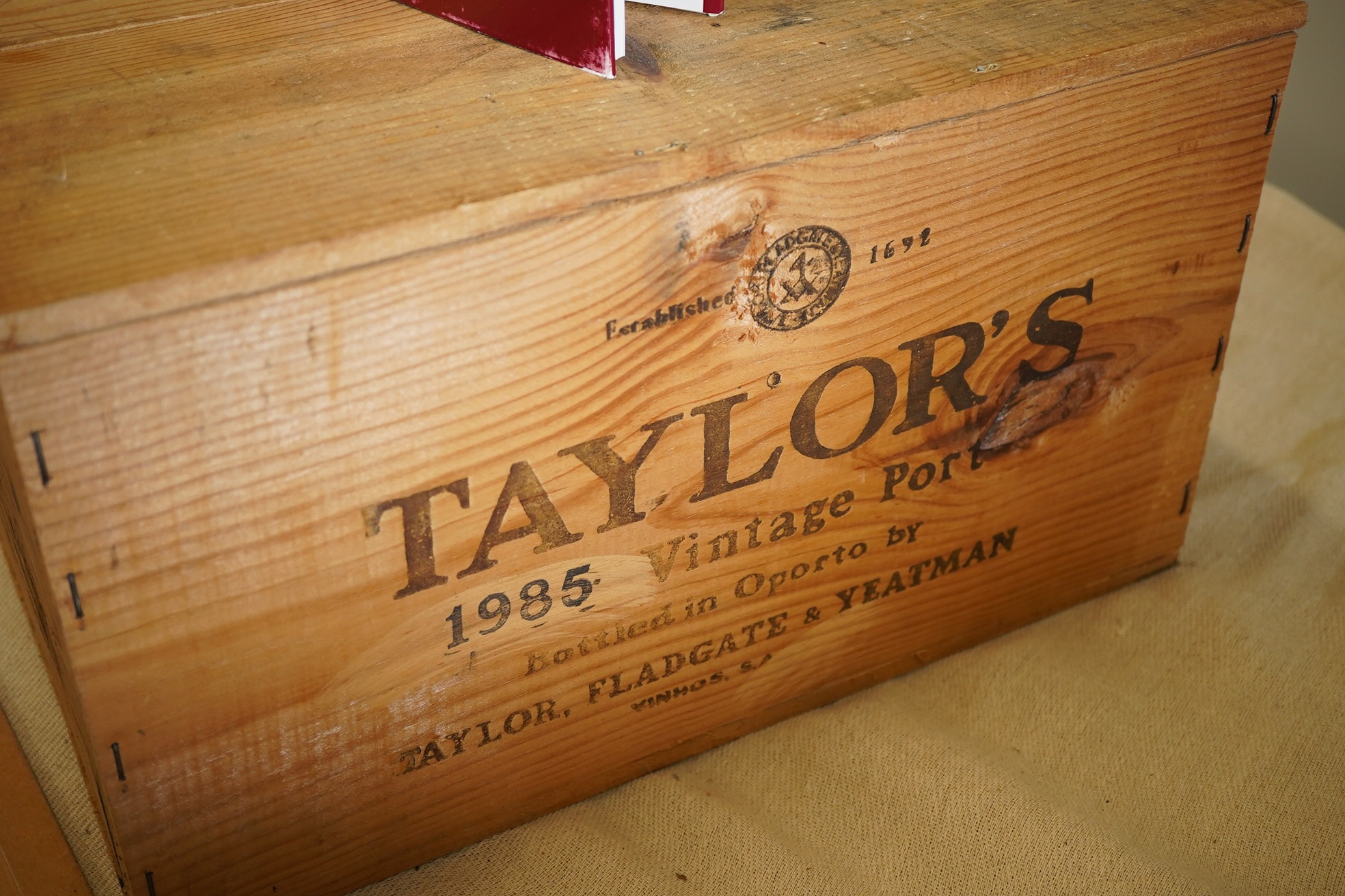 Twelve bottles of 1985 Taylor's vintage port (O.W.C), together with a book on port by Oliver Knox